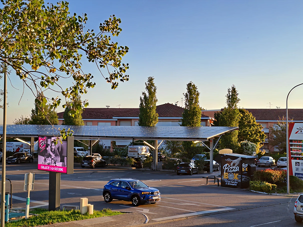 Vue aérienne des ombrières photovoltaïques installées sur le parking de l'Intermarché de Ramonville avec des panneaux solaires protégeant les véhicules